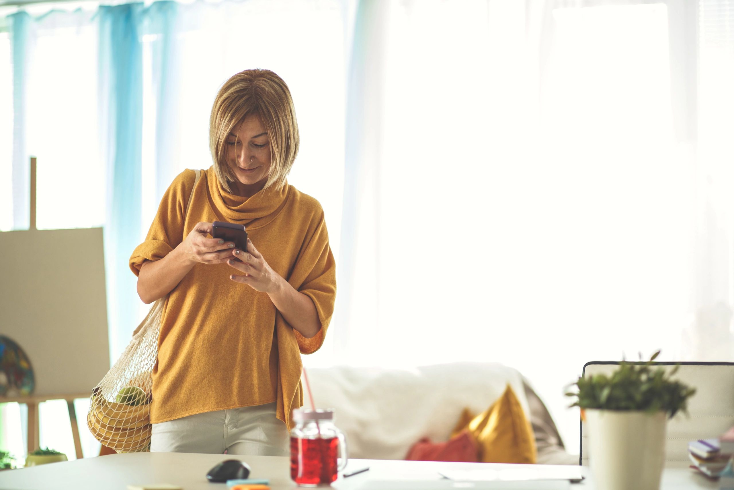 Person checking messages on a smartphone at home