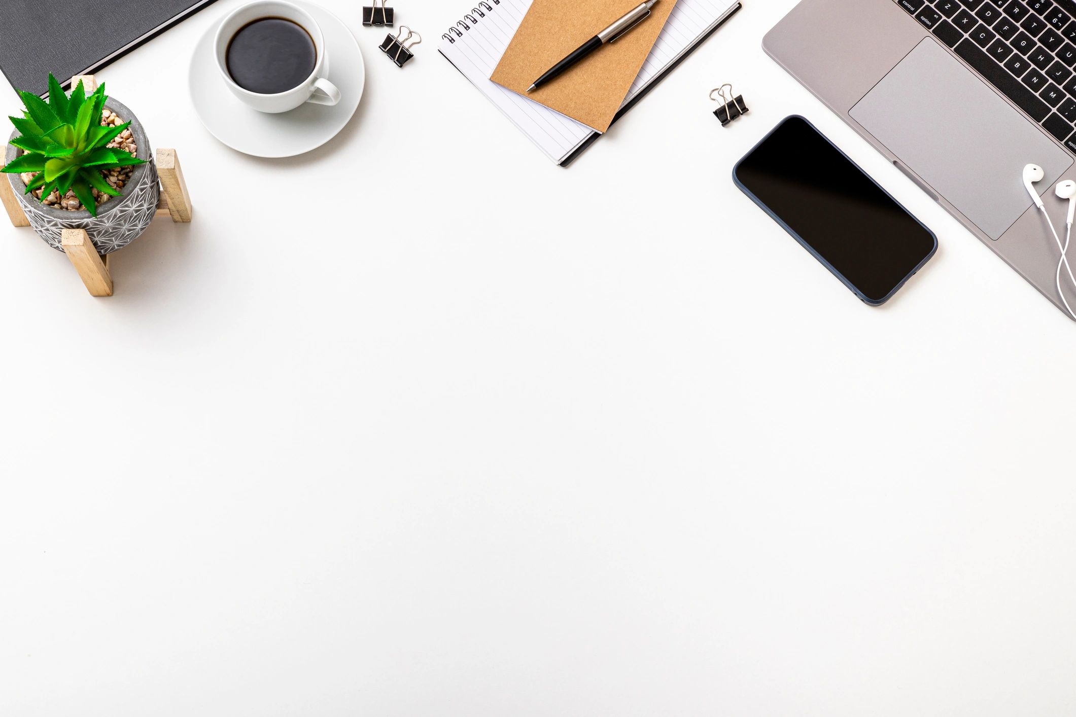 Top-down desk scene featuring a smartphone and workspace items with copy space