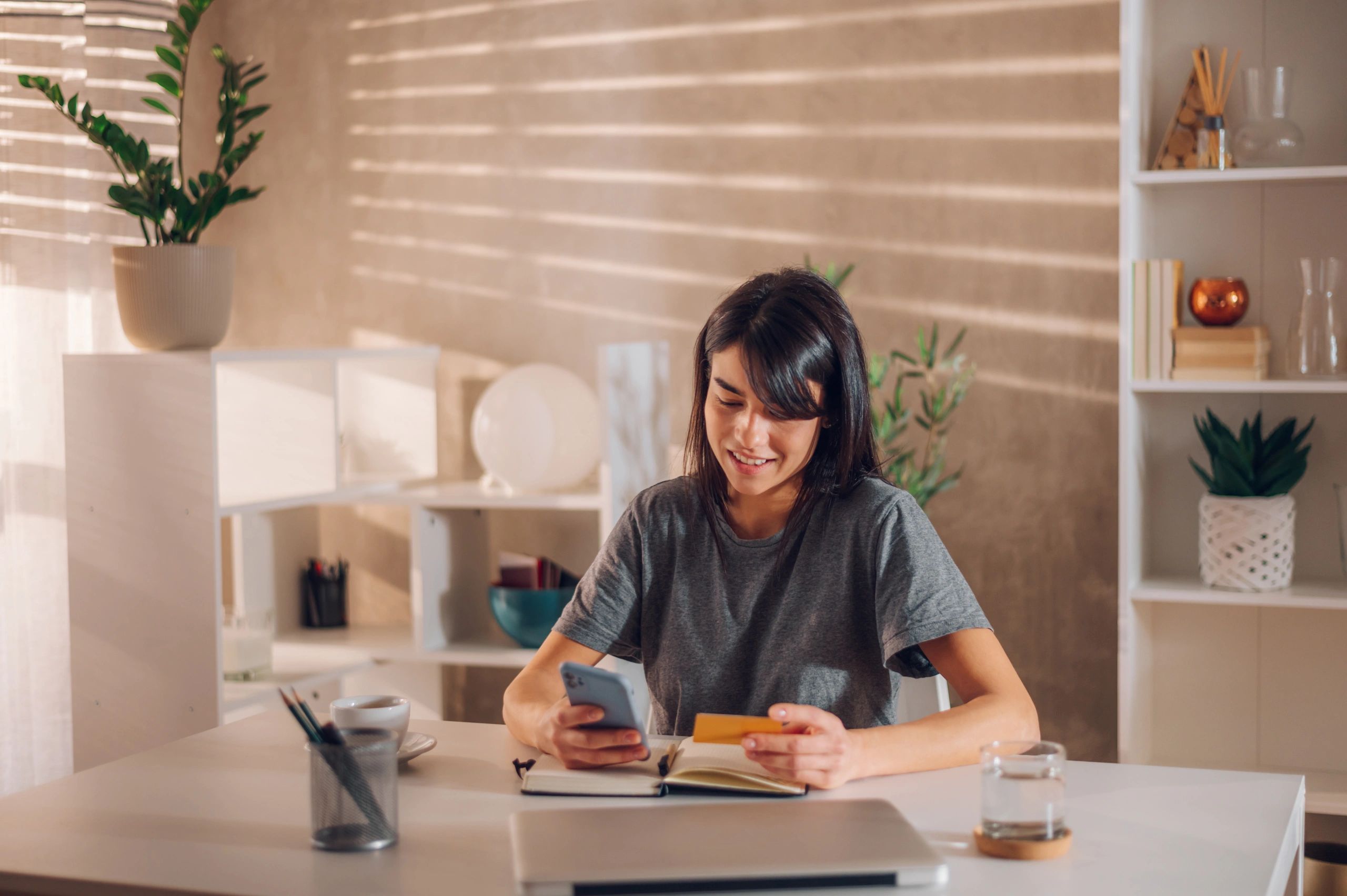 Person making an online payment on a smartphone at a desk