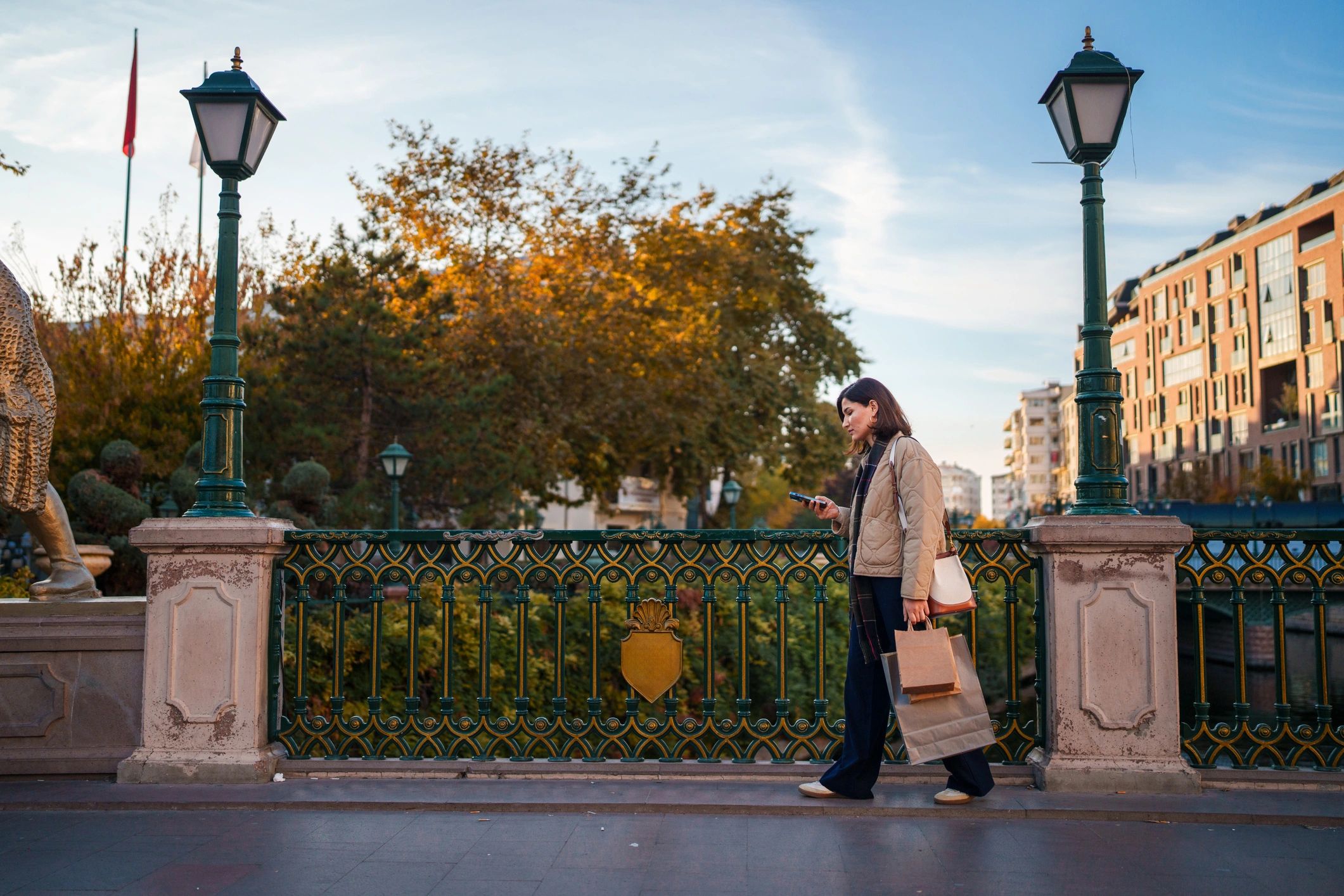 Woman using a smartphone while walking with shopping bags